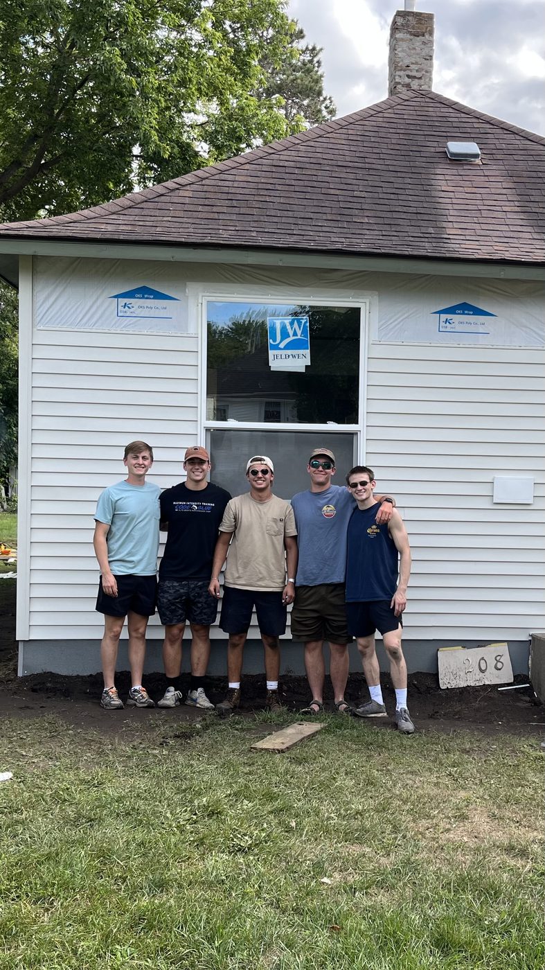 Isaac and four others in front of the newly-sided house