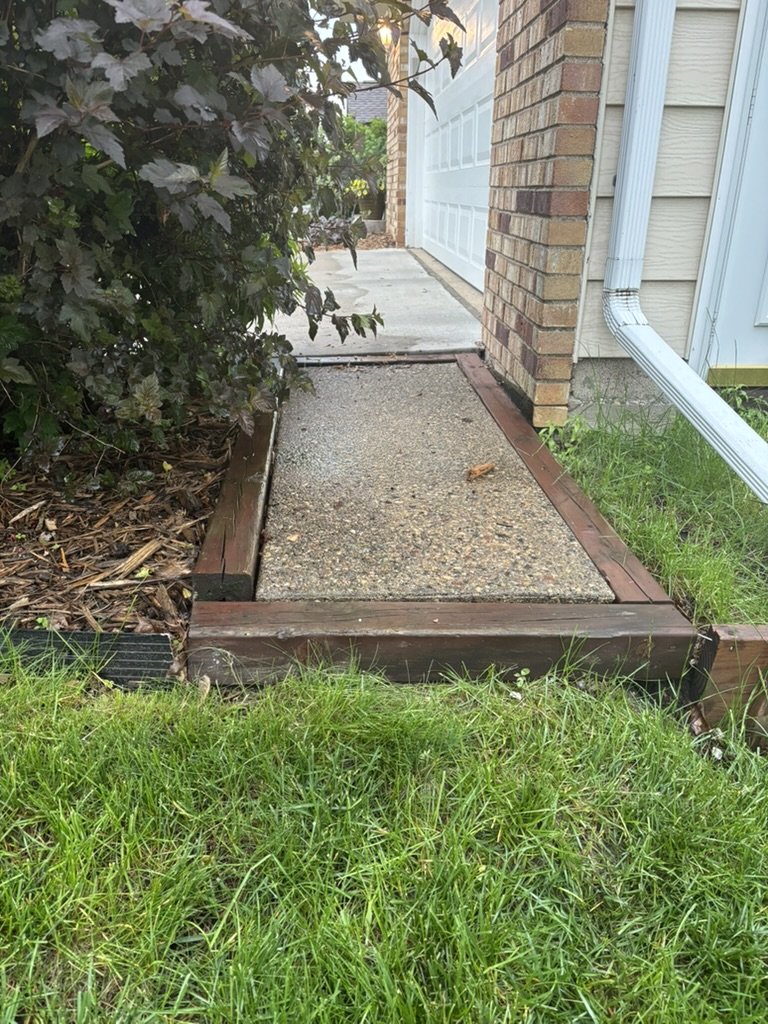 Existing concrete walkway with wood edging before the project began