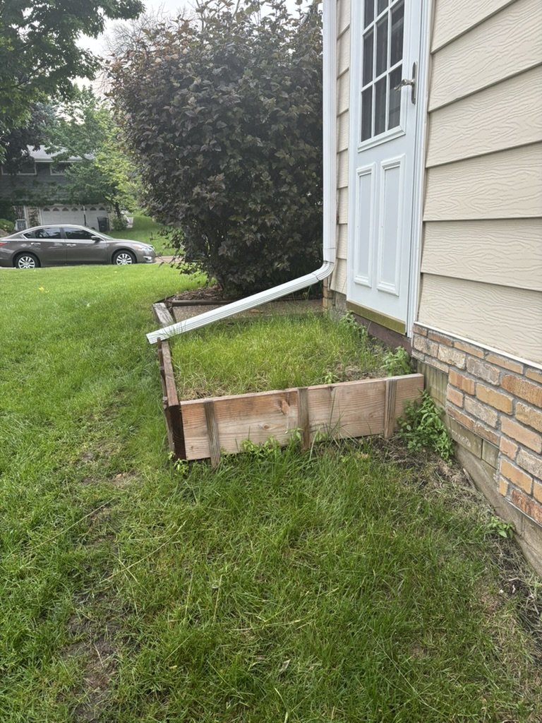Old wood retaining box with grass planted inside it before the project began
