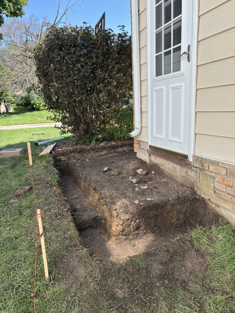 Early excavation for the retaining wall with a string line staked out for leveling